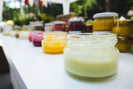various jars of fruit jam on wooden tableの写真素材