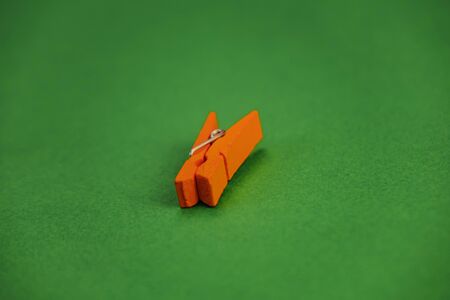 orange plastic clothespins on a green background