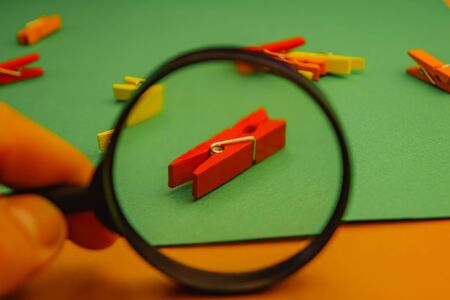 a bunch of clothes pegs through a magnifier on a green background.の写真素材
