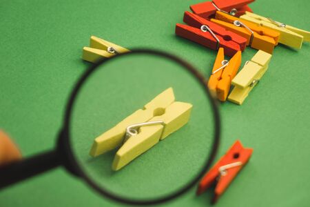 a bunch of clothes pegs through a magnifier on a green background.の写真素材