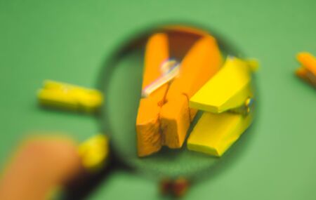 a bunch of clothes pegs through a magnifier on a green background.の写真素材