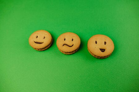 tasty cookies smiles on green background