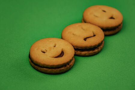 tasty cookies smiles on green backgroundの写真素材