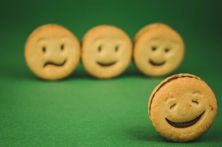 smiling cookies and different emotions on a green background.の写真素材