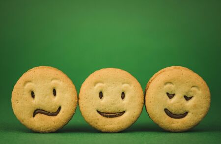 smiling cookies and different emotions on a green background.の写真素材