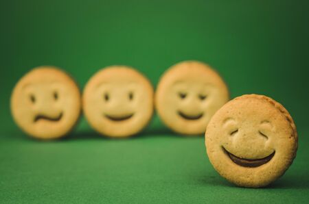 smiling cookies and different emotions on a green background.の写真素材