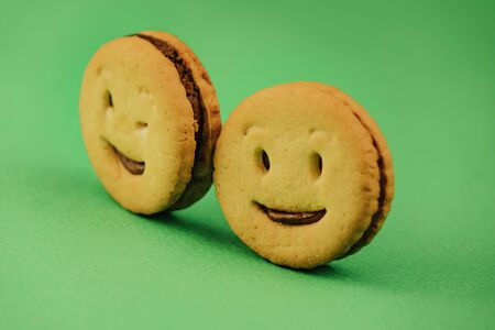 smiling cookies and different emotions on a green background.