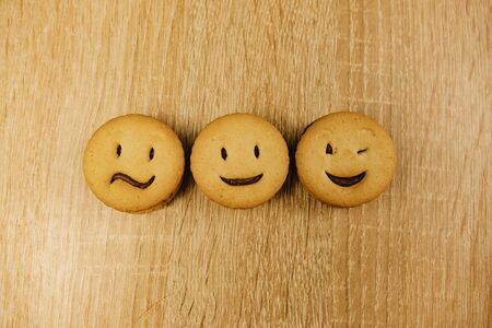 smiling cookies and different emotions on a wood backgroundの写真素材