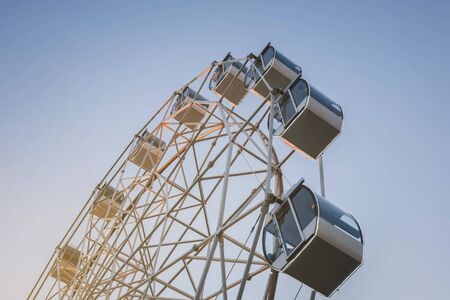 white tall ferris wheel in sight of a blue cloudless sky.の写真素材