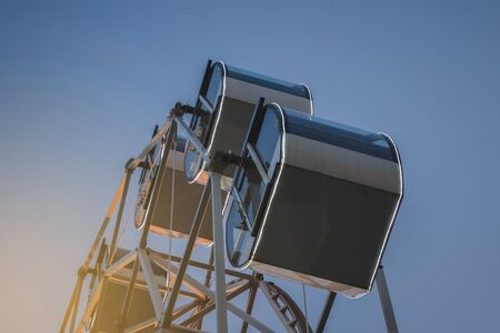 white tall ferris wheel in sight of a blue cloudless sky.の写真素材