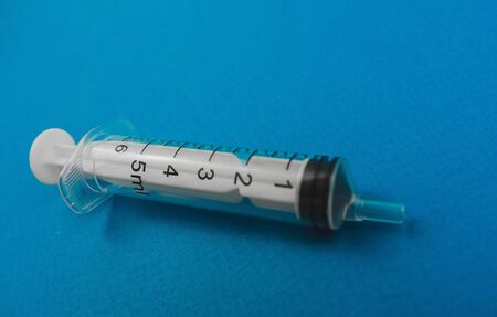 medical syringe lying on a blue background.の写真素材