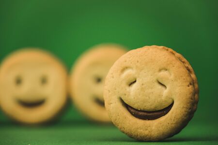smiling cookies and different emotions on a green background.の写真素材