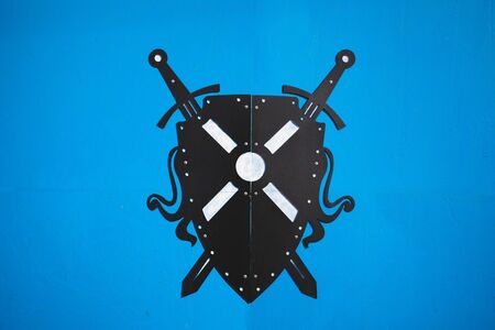 swords and shield isolated on blue backgroundの写真素材