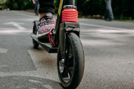 female legs standing on scooter frame bottom.の写真素材