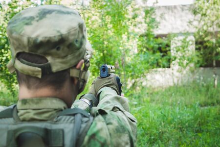 military in the form of aiming and trying to shoot a gun. rear viewの写真素材