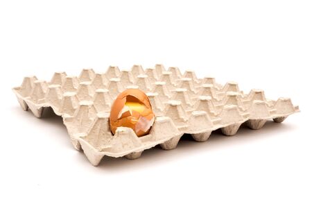 Carton packaging for eggs with broken eggshell on a light background.の写真素材