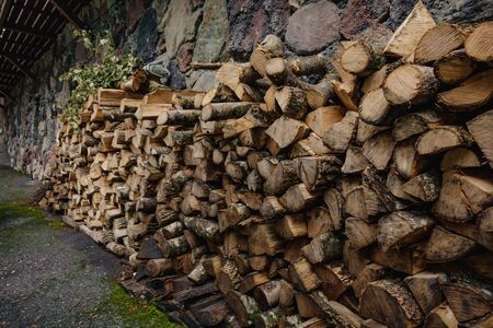 a pile of wood neatly stacked against the wallの写真素材
