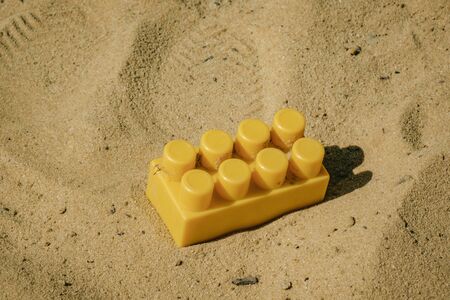 part of the children's designer yellow lying on the sand.の写真素材