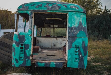 the back of an old abandoned green bus in a field.の写真素材