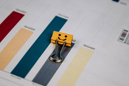two paper clips lying on a table with papers.