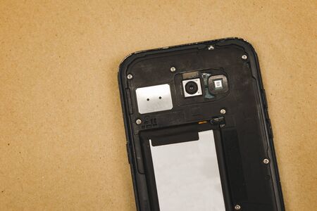 Disassembled cell phone isolated on brown background.の写真素材