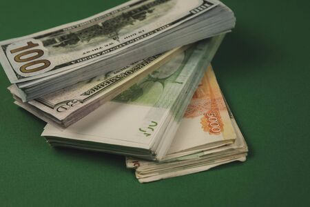several wads of cash lying on top of each other on a green background.の写真素材