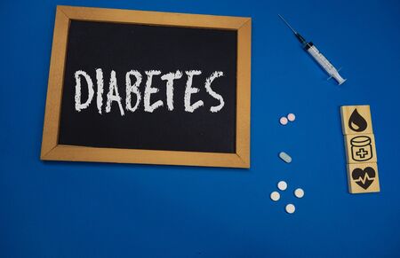 wooden tablet on blue medical table with the word DIABETESの写真素材