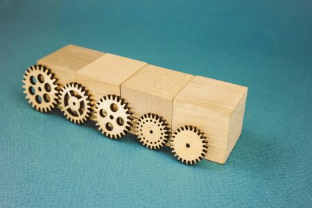 5 wooden gears standing leaning on wooden cubes