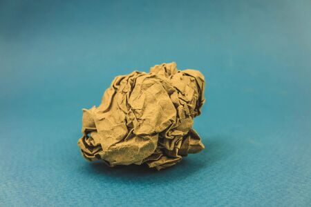 a piece of crumpled brown paper on a blue background.