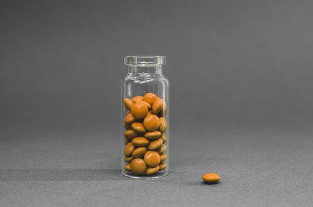 orange vitamins standing in a glass flask. black and white photo.の写真素材
