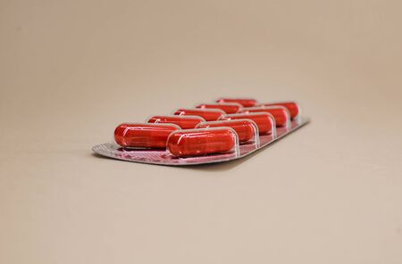 a pack of red capsule tablets in the amount of ten pieces