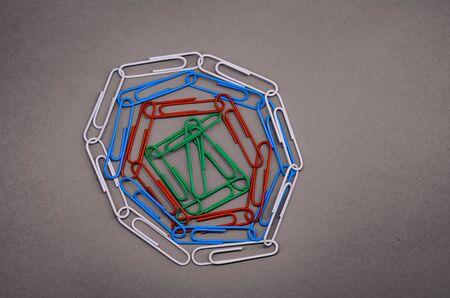 a bunch of paper clips of different colors on a gray background. black and white photo.の写真素材