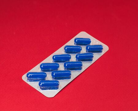 pack of blue pills on a red backgroundの写真素材
