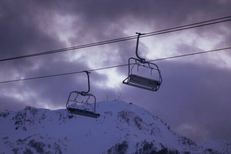 empty lifts overlooking the mountains in the eveningの写真素材