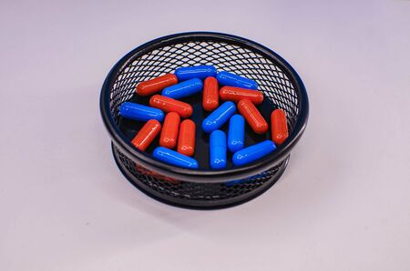 lots of red and blue tablets in a black basketの写真素材