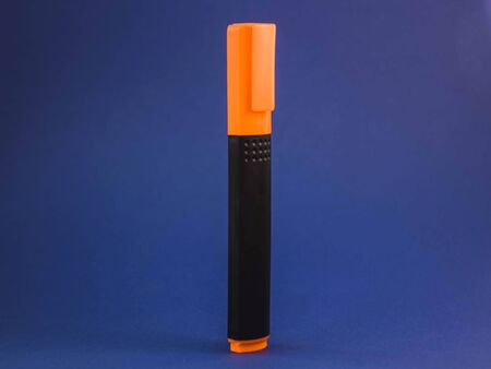 standing orange marker on a blue backgroundの写真素材