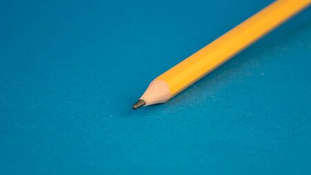 front part yellow pencil on a blue backgroundの写真素材