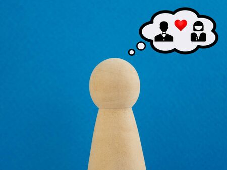 Wooden figurine dreams of love with a woman on a blue backgroundの写真素材