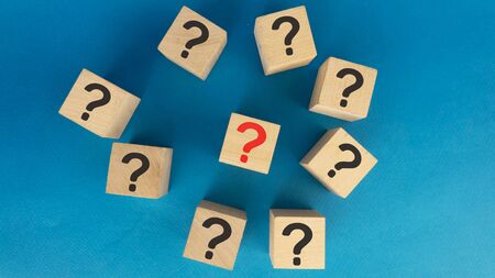 heap of black question marks and one red on wooden cubes.