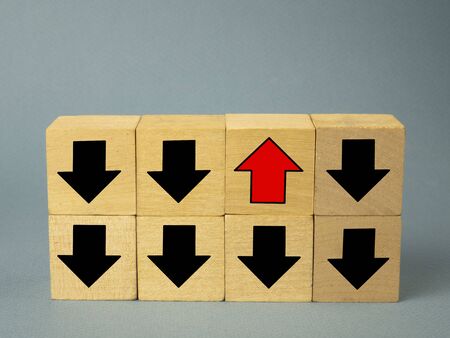 black arrows on wooden cubes and one red arrow pointing up, the concept of success.の写真素材