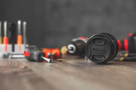 nikon lens in repair against the background of a pile of tools Russia. Moscow April 10, 2020.のeditorial素材