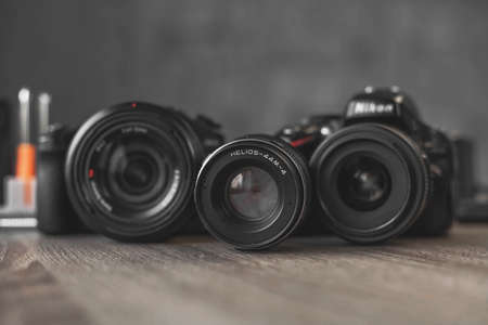 two cameras and a lens centered on a wooden table April 10, 2020.のeditorial素材