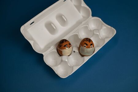 a bunch of masked eggs during Quarantine. on a blue background