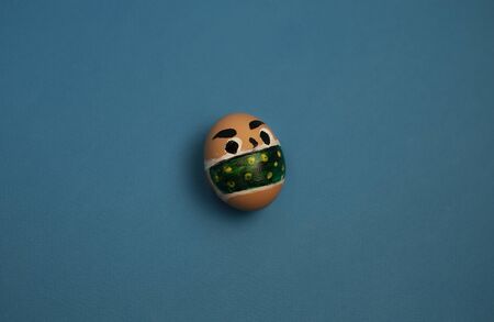 one egg with eyes and a mask on a blue background.の写真素材