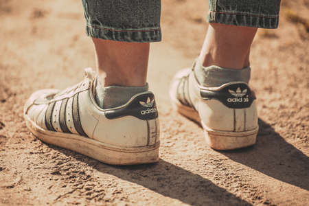 Russia Moscow April 20, 2020 women's feet in white old Adidas sneakersのeditorial素材