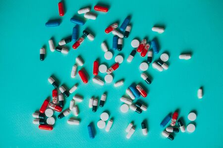 a bunch of colorful pills on a blue background.の写真素材