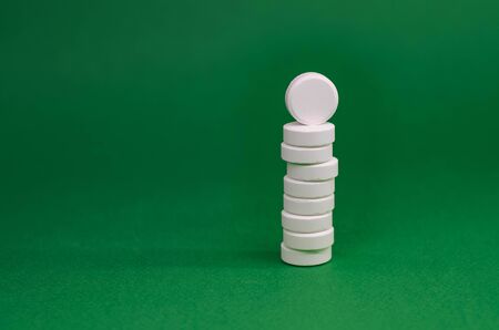 tower of white tablets on a green background.の写真素材