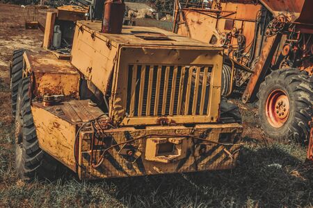 old abandoned agricultural machinery stands in a field.の写真素材