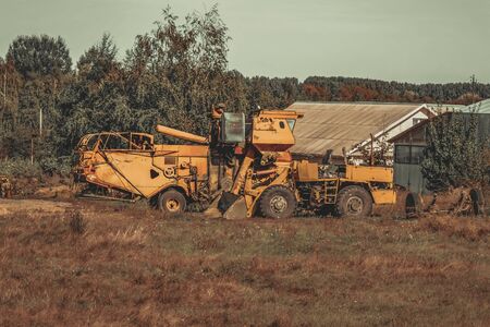 old abandoned agricultural machinery stands in a field.の写真素材