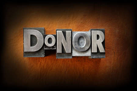 The word donor made from vintage lead letterpress type on a leather background.の写真素材